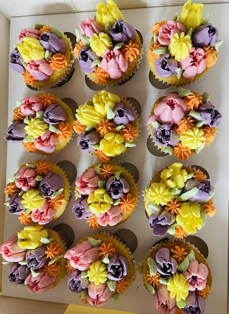cupcakes made in kent with orange and purple flowers on top